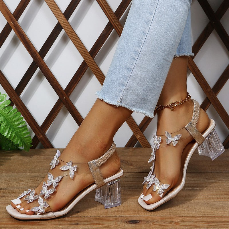 Damen Glamouröse Sandalen mit funkelnden Schmetterlingsdetails und transparentem Blockabsatz Selmira